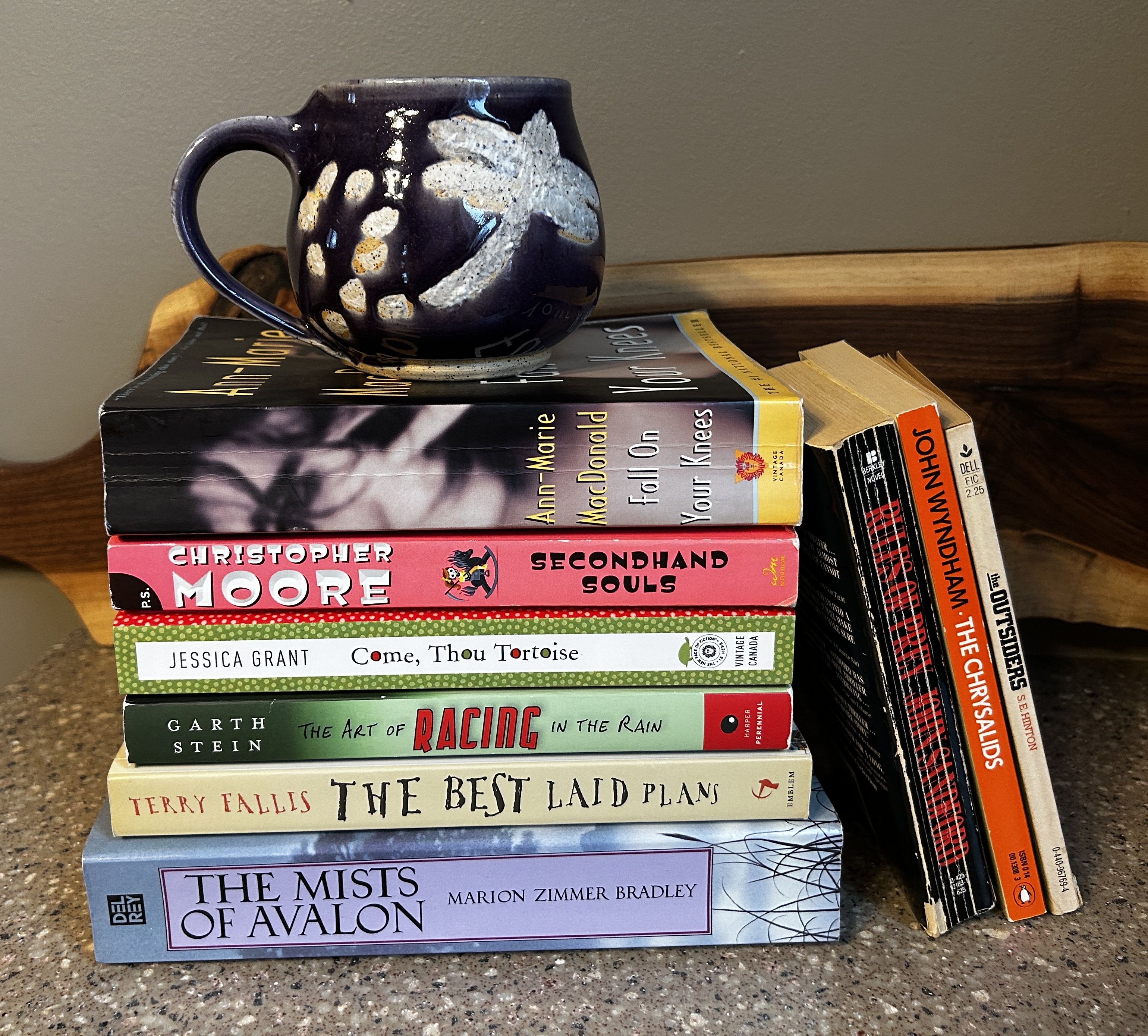 Photo of some of my books along with my favourite mug which is purple and has a dragonfly on it